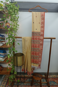 Cream Pattachitra Saree — Warm Wooden Shelf Ambiance